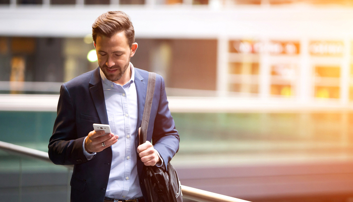 A man walking and using his smartphone.