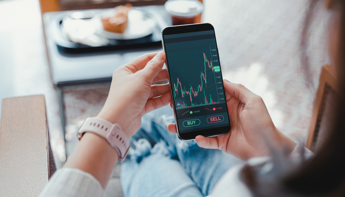 A woman checking investment performance on a phone.