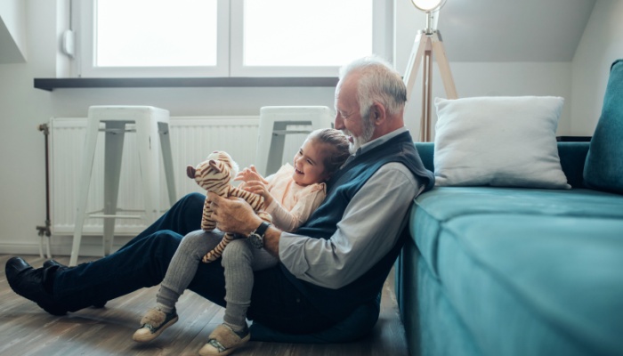 A grandfather playing with his granddaughter.