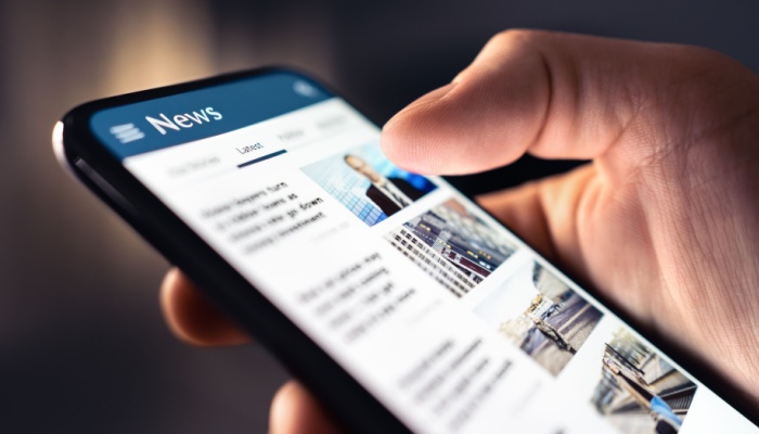 A person looking at a news feed on their phone