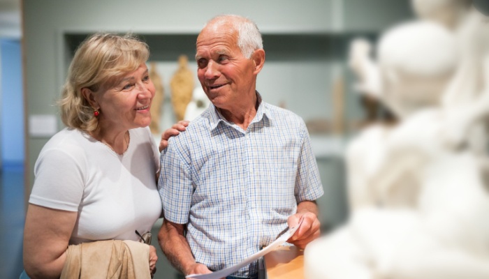 A couple looking at a statue in a museum.
