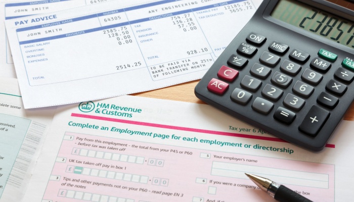 Paperwork relating to a tax return, with calculator and pen lying on it