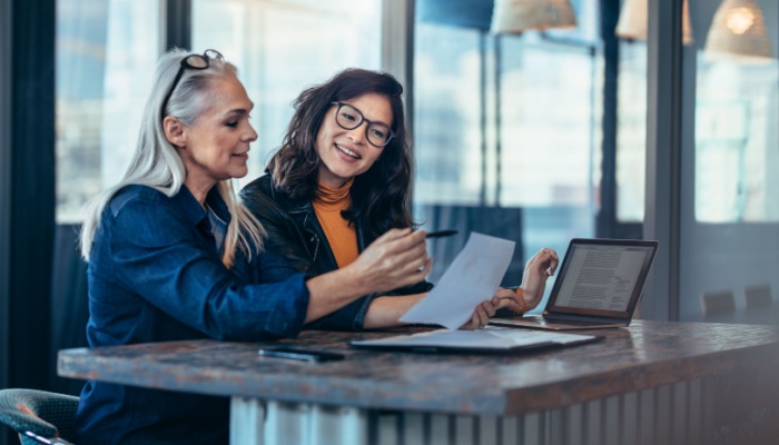 A woman talking to a colleague in an office.