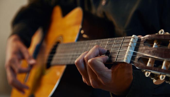 A close-up of someone playing a guitar.