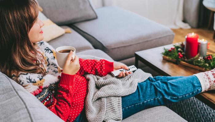 A woman relaxing wearing a Christmas jumper.