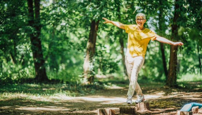 A woman doing balancing exercises outdoors.