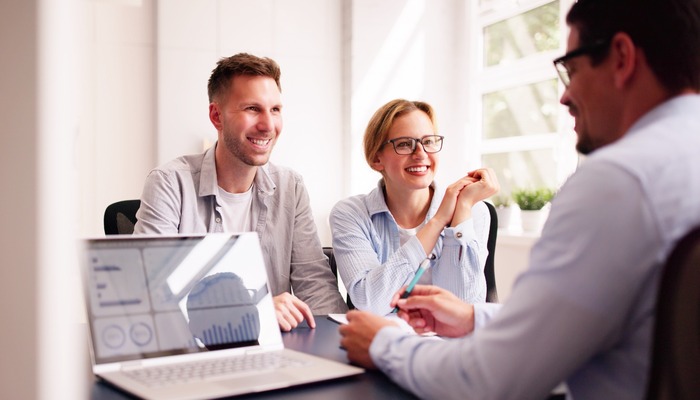 A couple happily talking with their financial planner.
