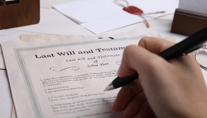 A person signing a will.